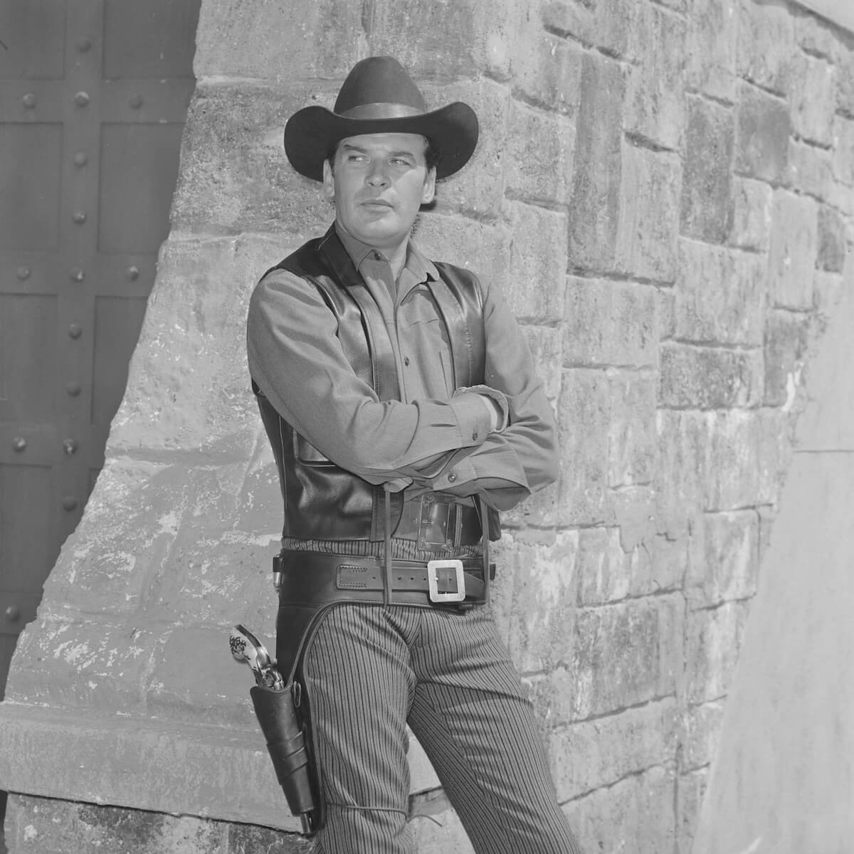 Peter Breck standing with arms crossed dressed in Western gear