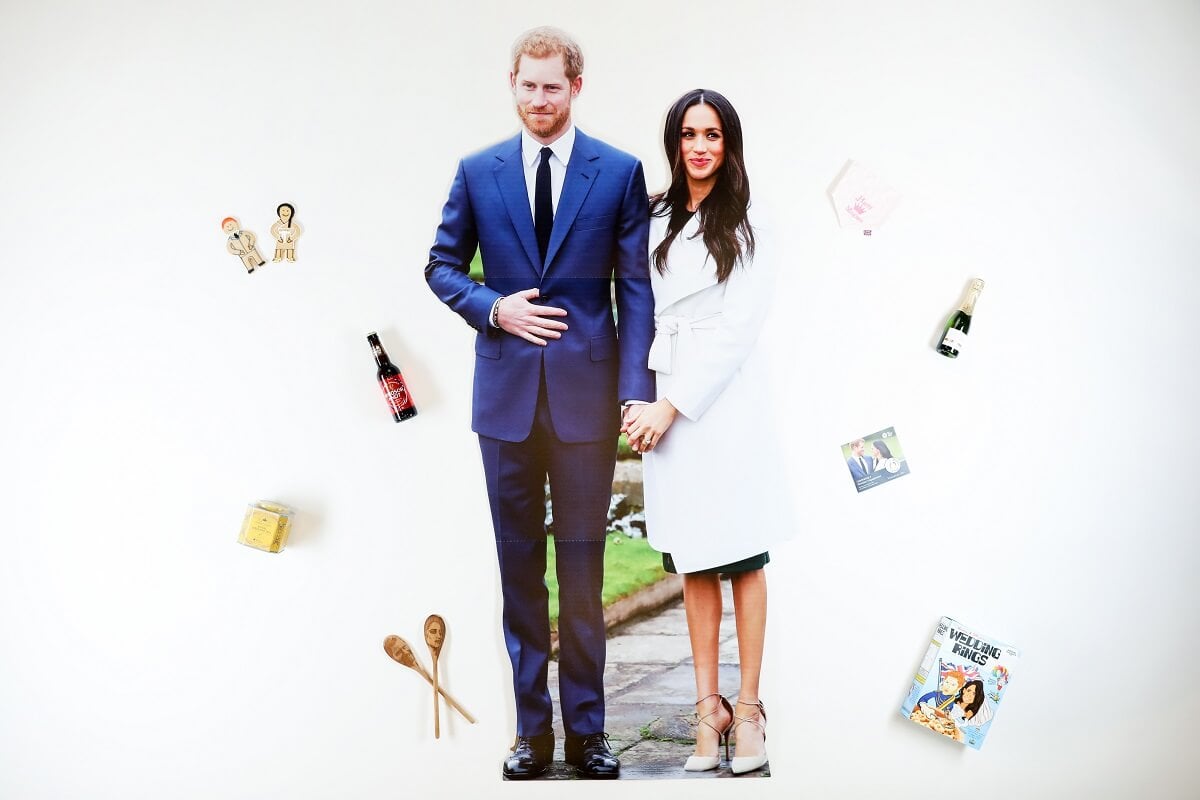 Photo of Prince Harry and Meghan Markle, who have grown thoir net worth since leaving the royal family, surrounded by memorabilia bearing their names and images