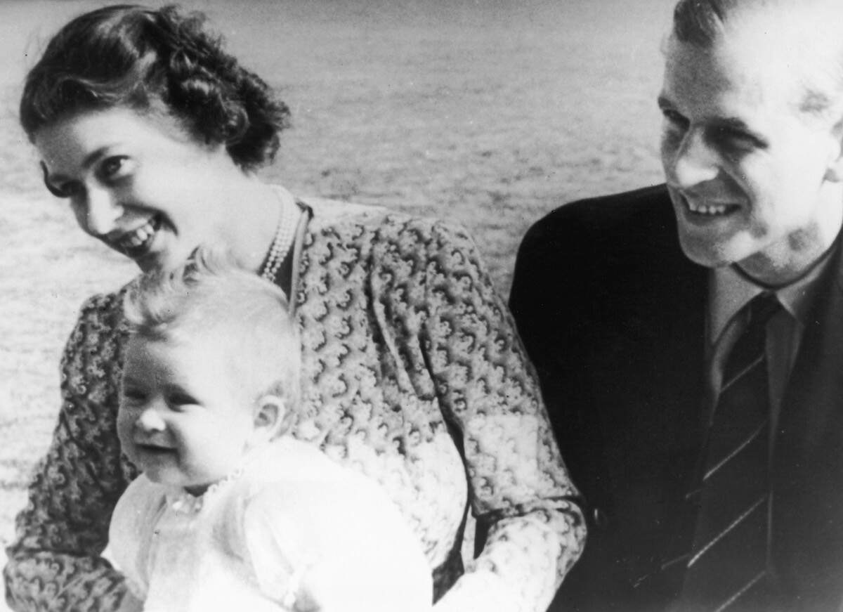 Then-Princess Elizabeth holds her baby son Prince Charles with her husband Prince Philip in 1949
