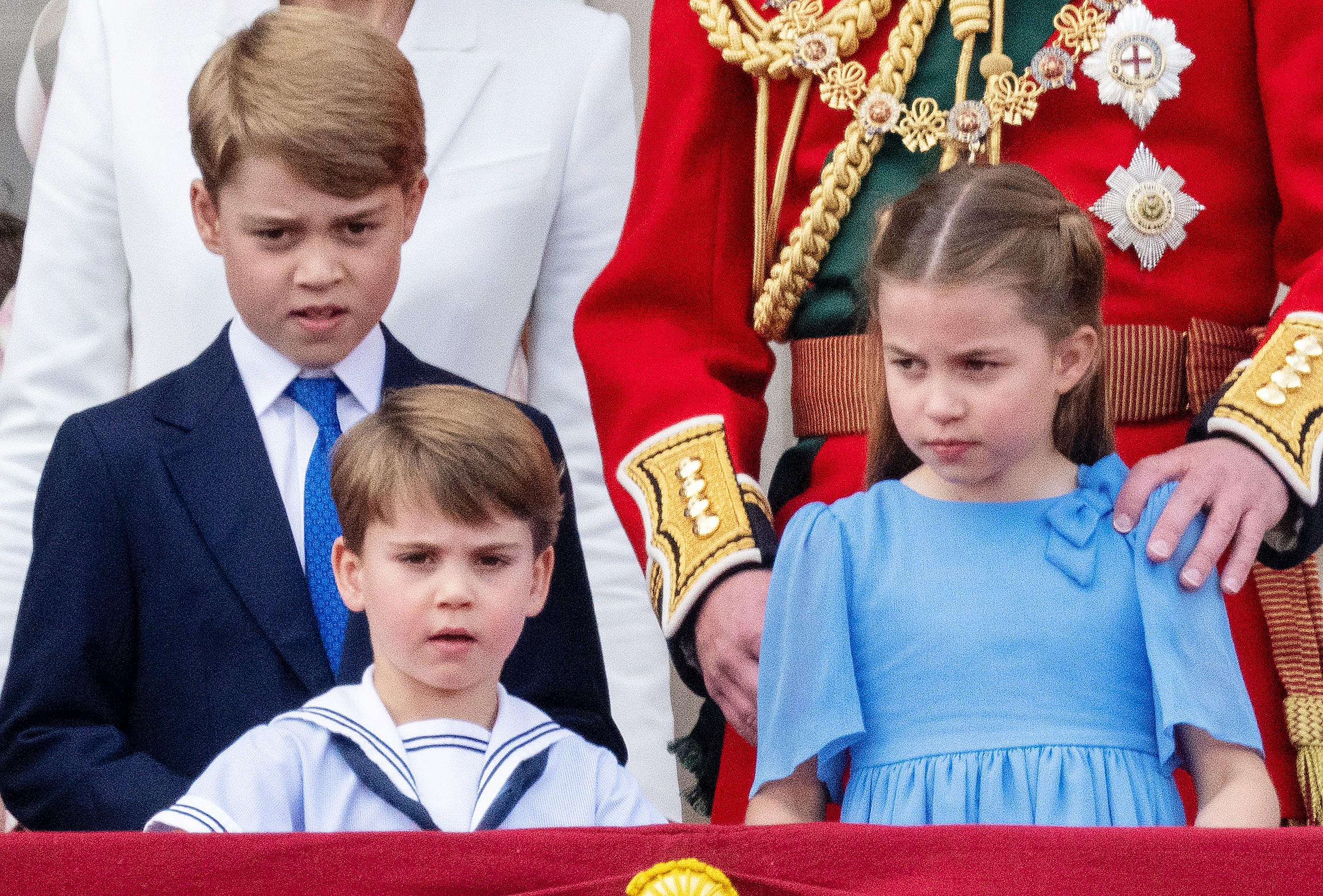 Prince George, Prince Louis, and Princess Charlotte stand on the balcony at Buckingham Palace.