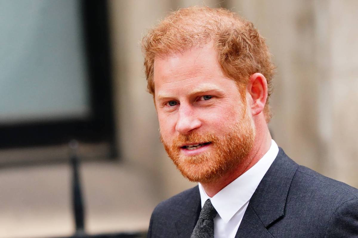 Prince Harry, who is attending the coronation alone but should bring Prince Archie and Princess Lilibet, according to an author, looks on