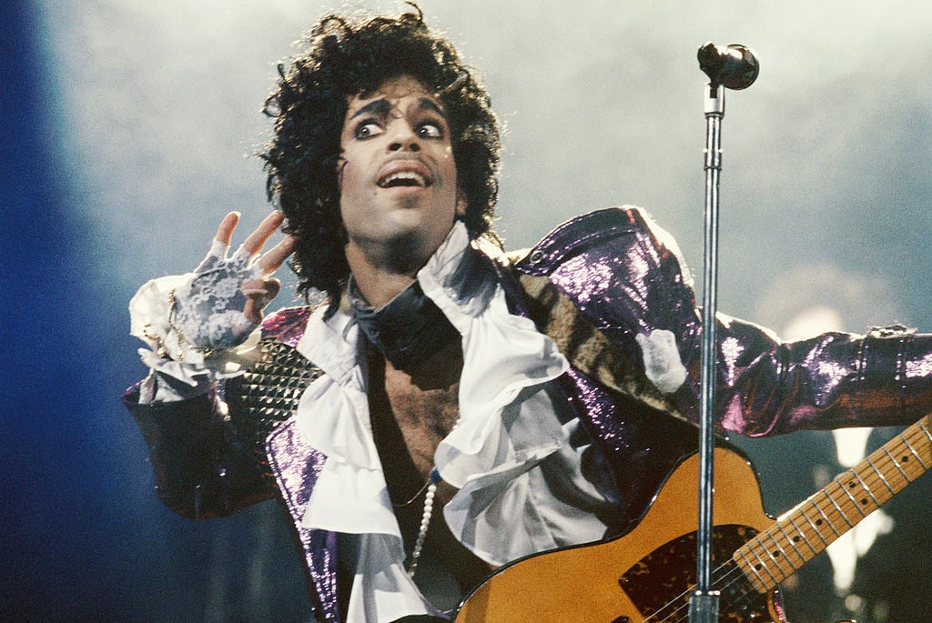 Prince on stage, putting his hand to his ear.