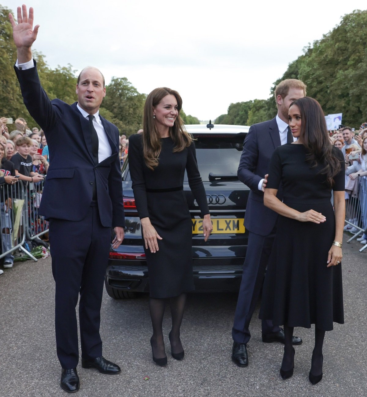 Prince William waving to crowds on the Long Walk at Windsor Castle after walkabout with Kate Middleton, Prince Harry, and Meghan Markle