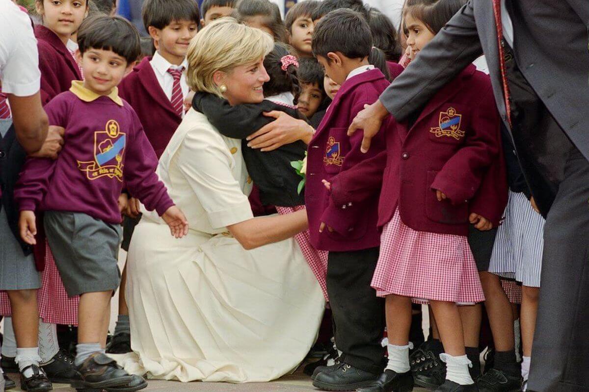 Princess Diana, whose body language with children hinted at 'breath of change' in the royal family, hugs a child