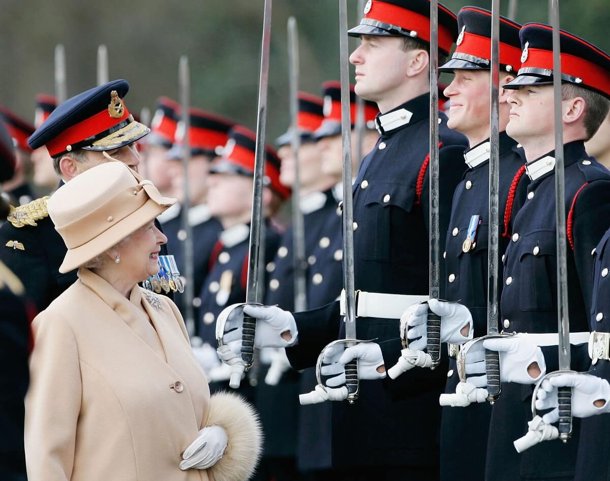 Queen Elizabeth II smiles at Prince Harry as she inspects soldiers at Sandhurst Military Academy