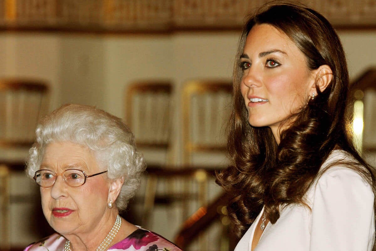 Queen Elizabeth II, who commented on Kate Middleton's wedding dress display, stands with Kate Middleton