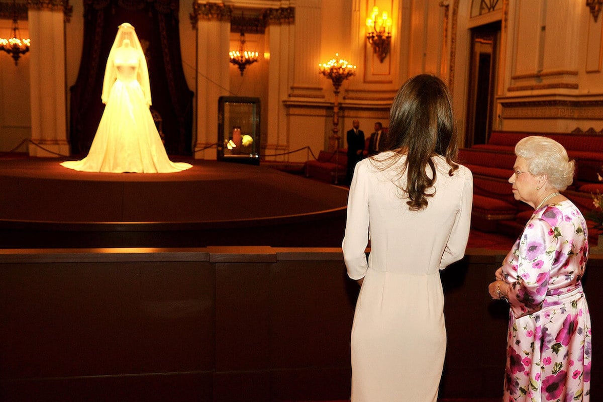 Queen Elizabeth and Kate Middleton look at a display of Kate Middleton's wedding dress