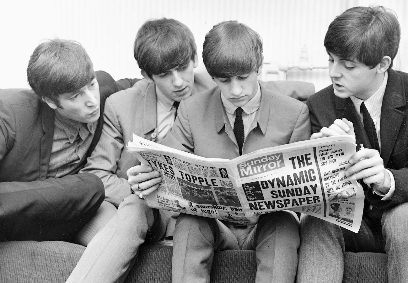 The Beatles reading a newspaper in 1963.