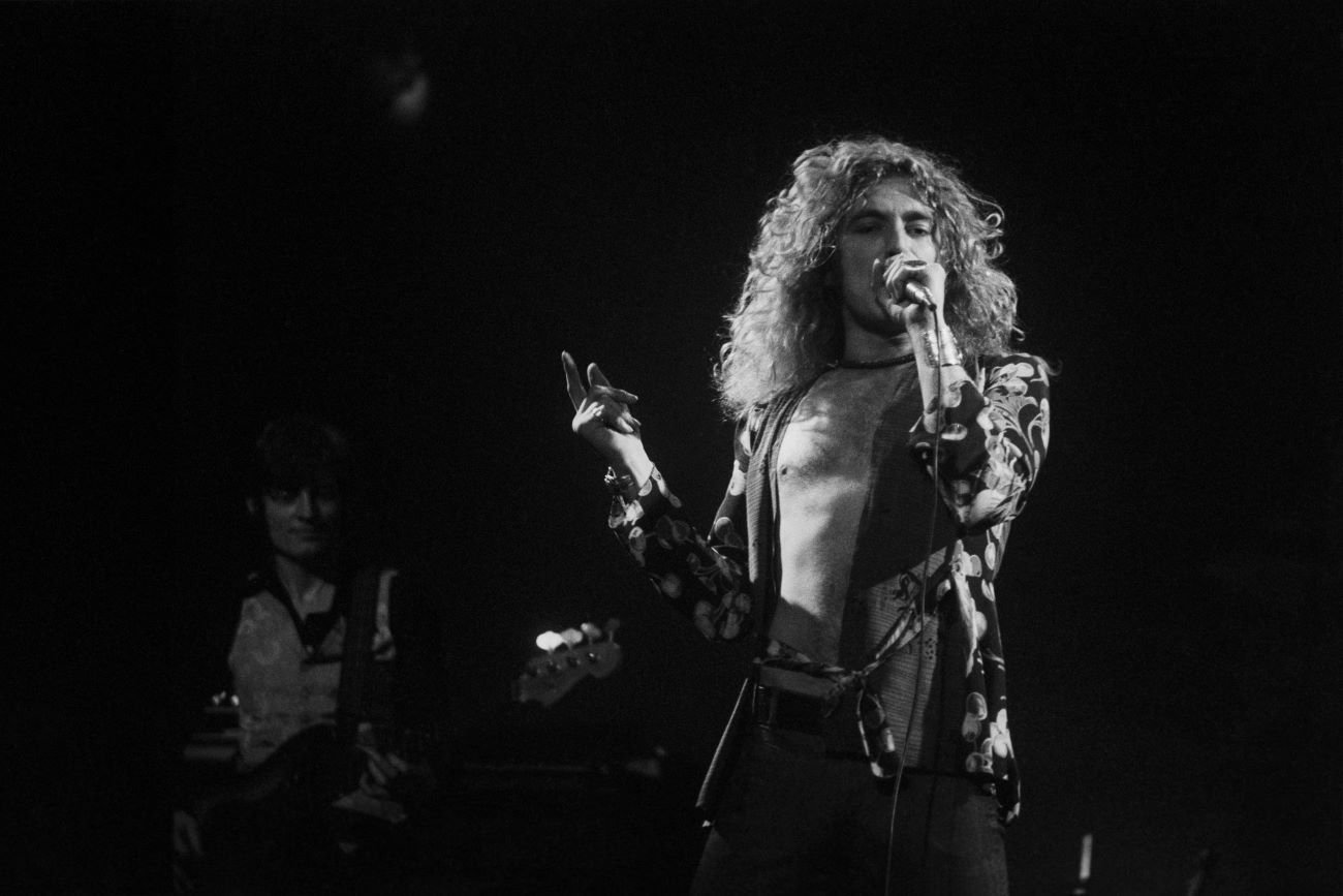 A black and white picture of Led Zeppelin's Robert Plant singing into a microphone.