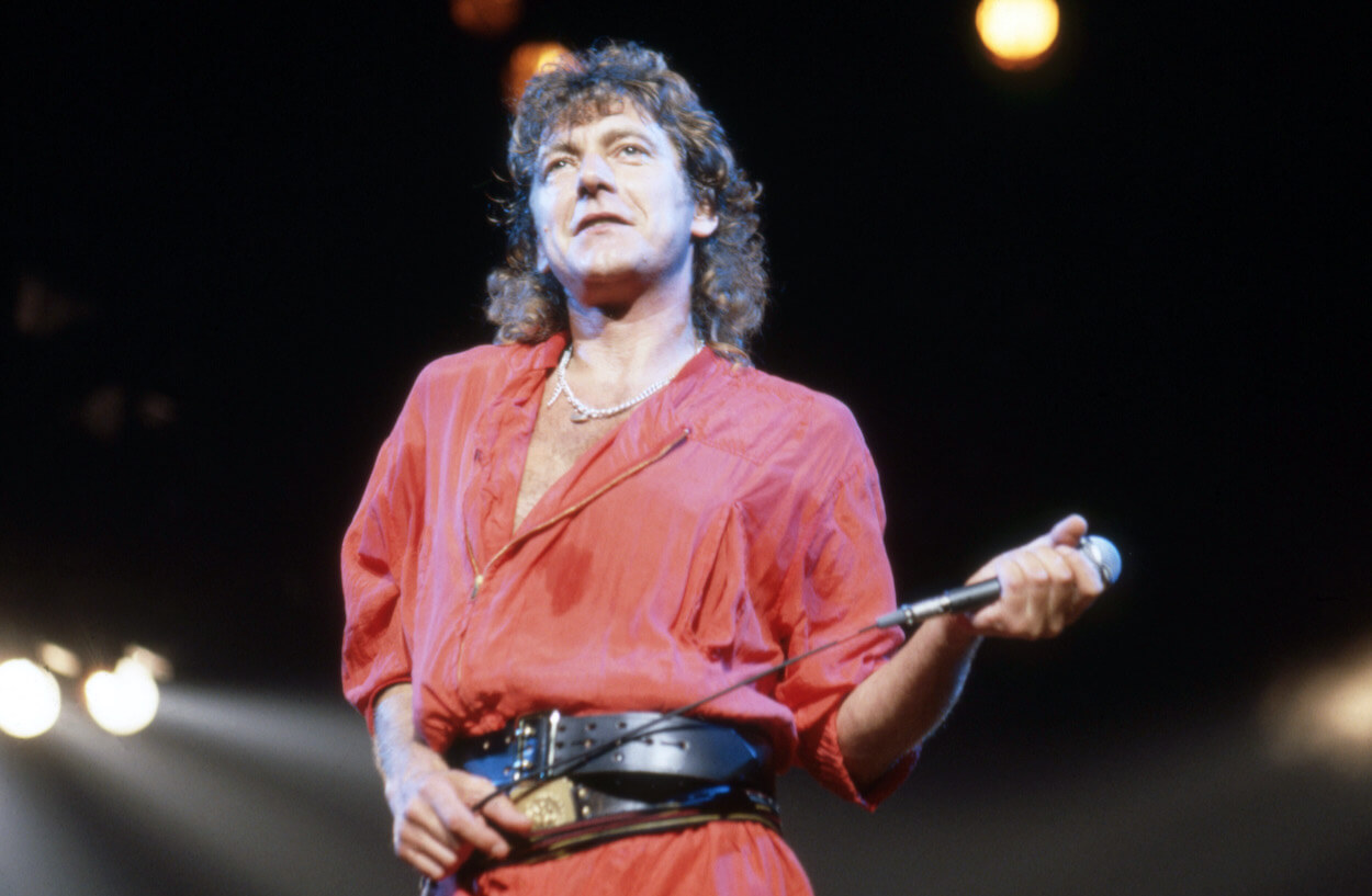 Led Zeppelin singer Robert Plant wears a red shirt as he holds the microphone during a 1983 concert in Detroit.