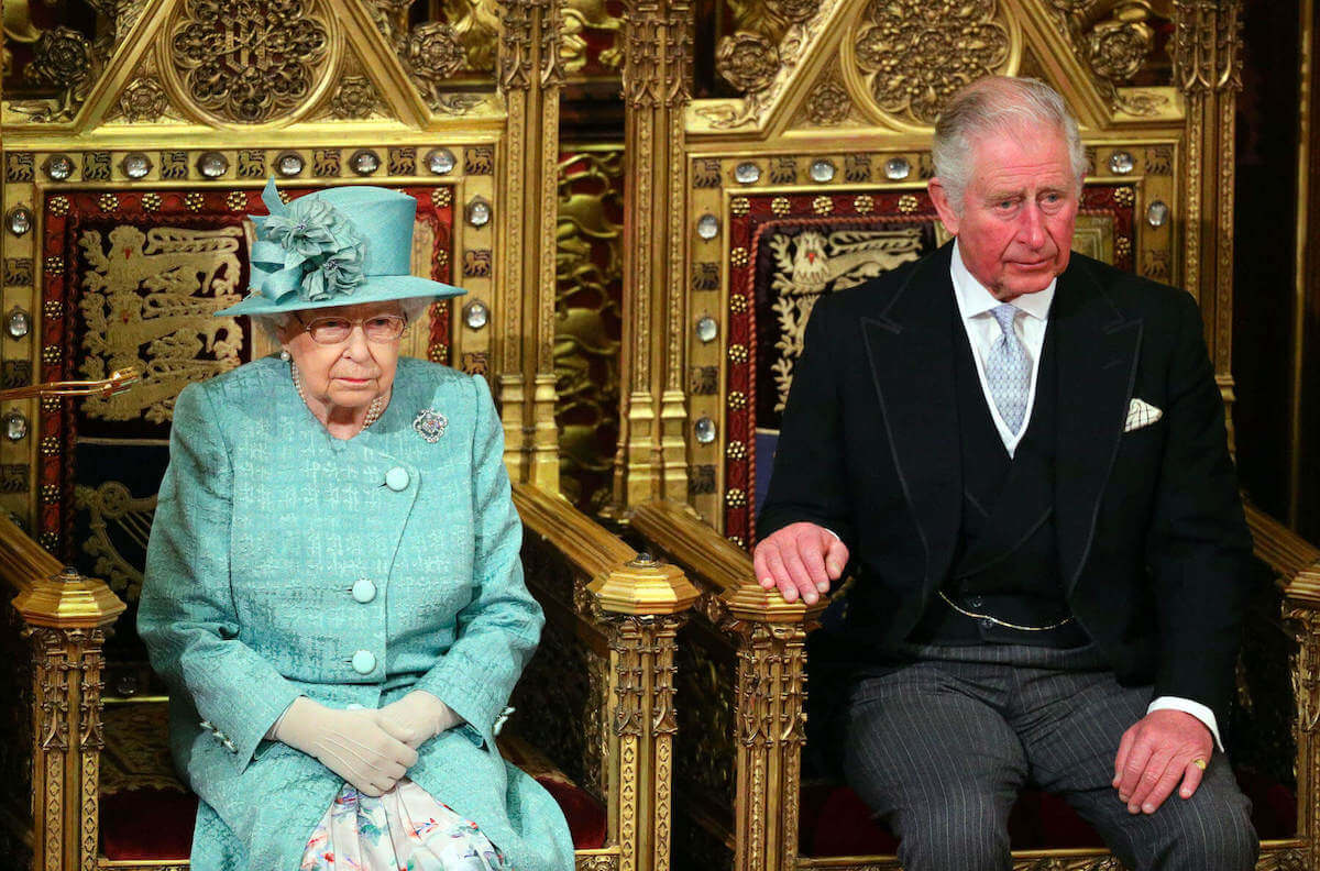 Queen Elizabeth II and King Charles III sitting on gilded thrones
