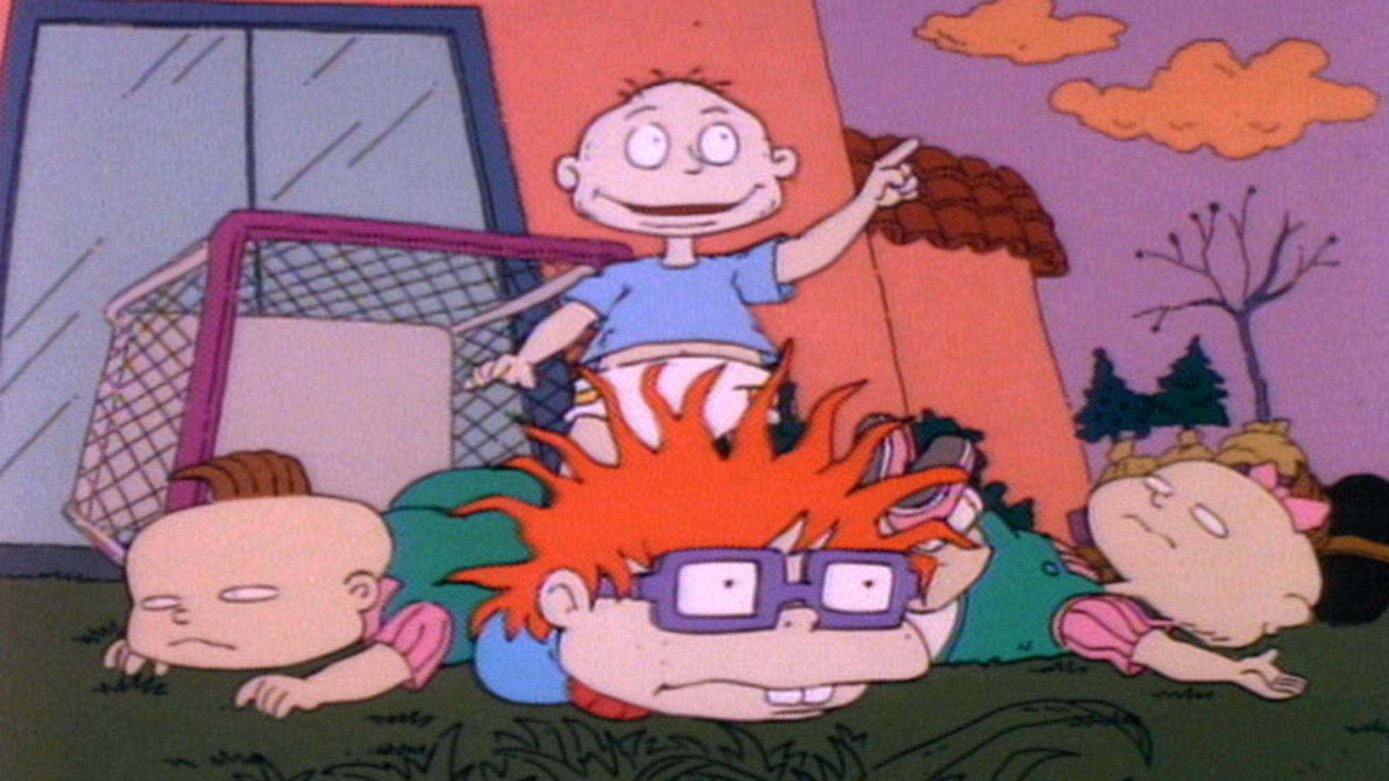 'Rugrats' Season 1 Episode 6 Phil, Tommy, Chuckie, and Lillian. Tommy is standing and pointing outward, while Phil, Chuckie, and Lillian are laying down on their stomachs in front of him.