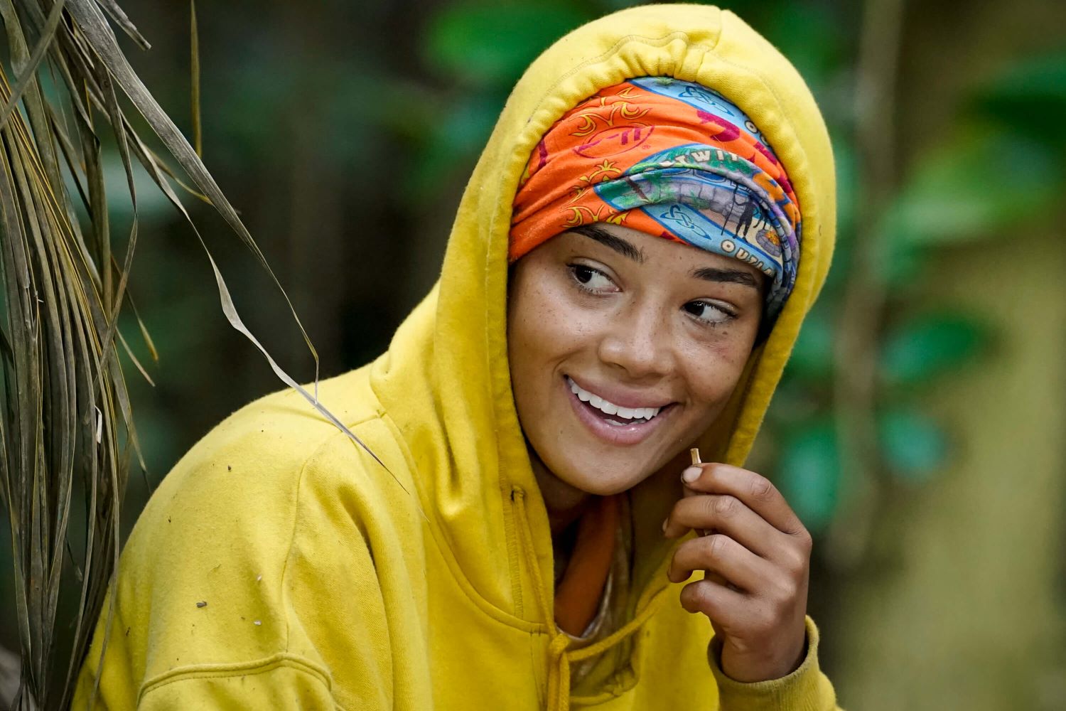 Lauren Harpe, who stars in 'Survivor 44' Episode 7, wears a yellow hoodie and her orange buff around her head.