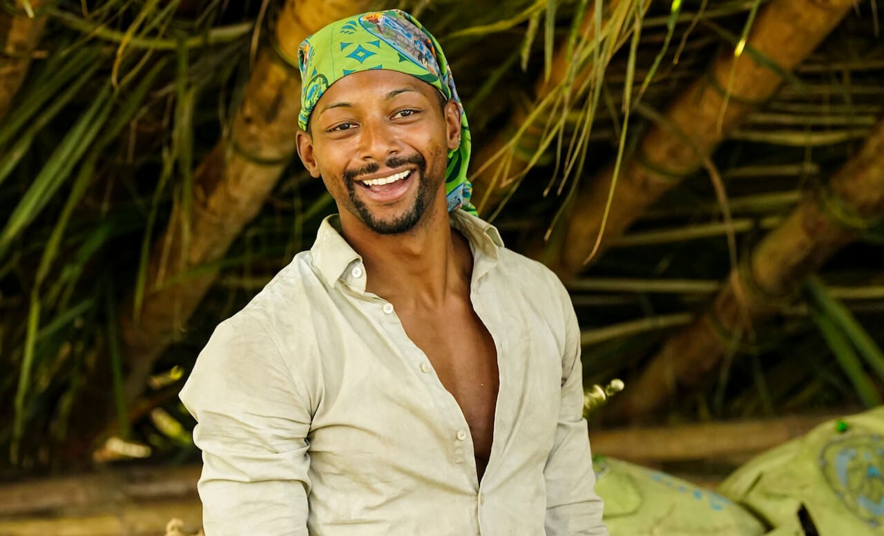 Josh Wilder smiles in front of the Soka Tribe shelter on 'Survivor 44.
