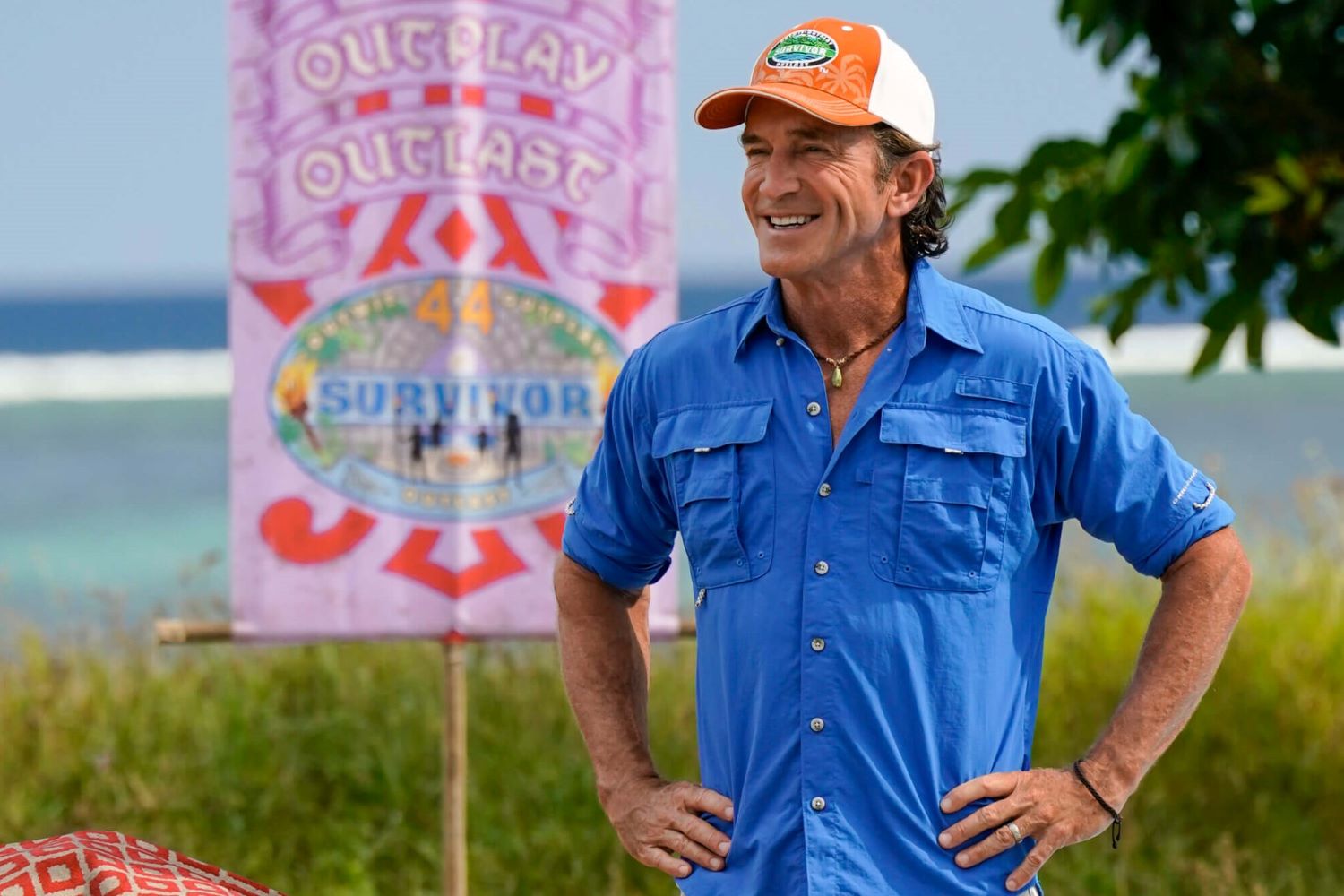 Jeff Probst, who has hosted every season of the CBS show 'Survivor,' wears a bright blue safari shirt and an orange and white 'Survivor' baseball cap.