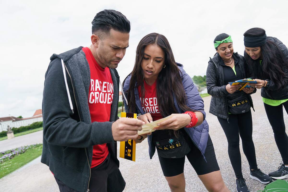 Two Amazing Race contestants check their maps