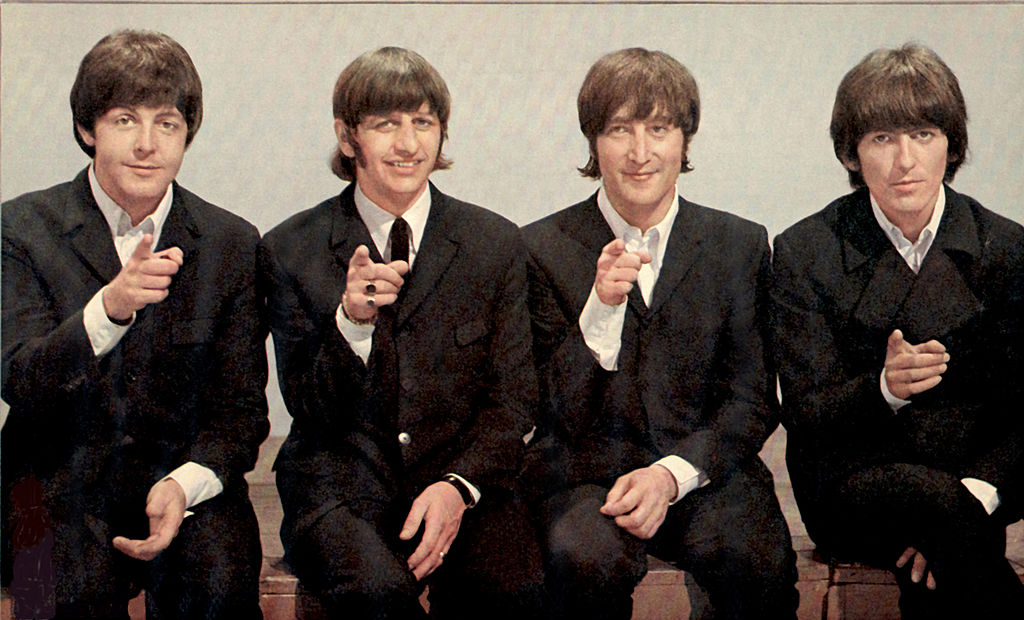 The Beatles all pointing at the camera.