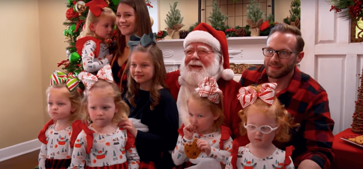 Adam and Danielle Busby and the Busby Quints pose for a photo with Santa in an episode of 'OutDaughtered'