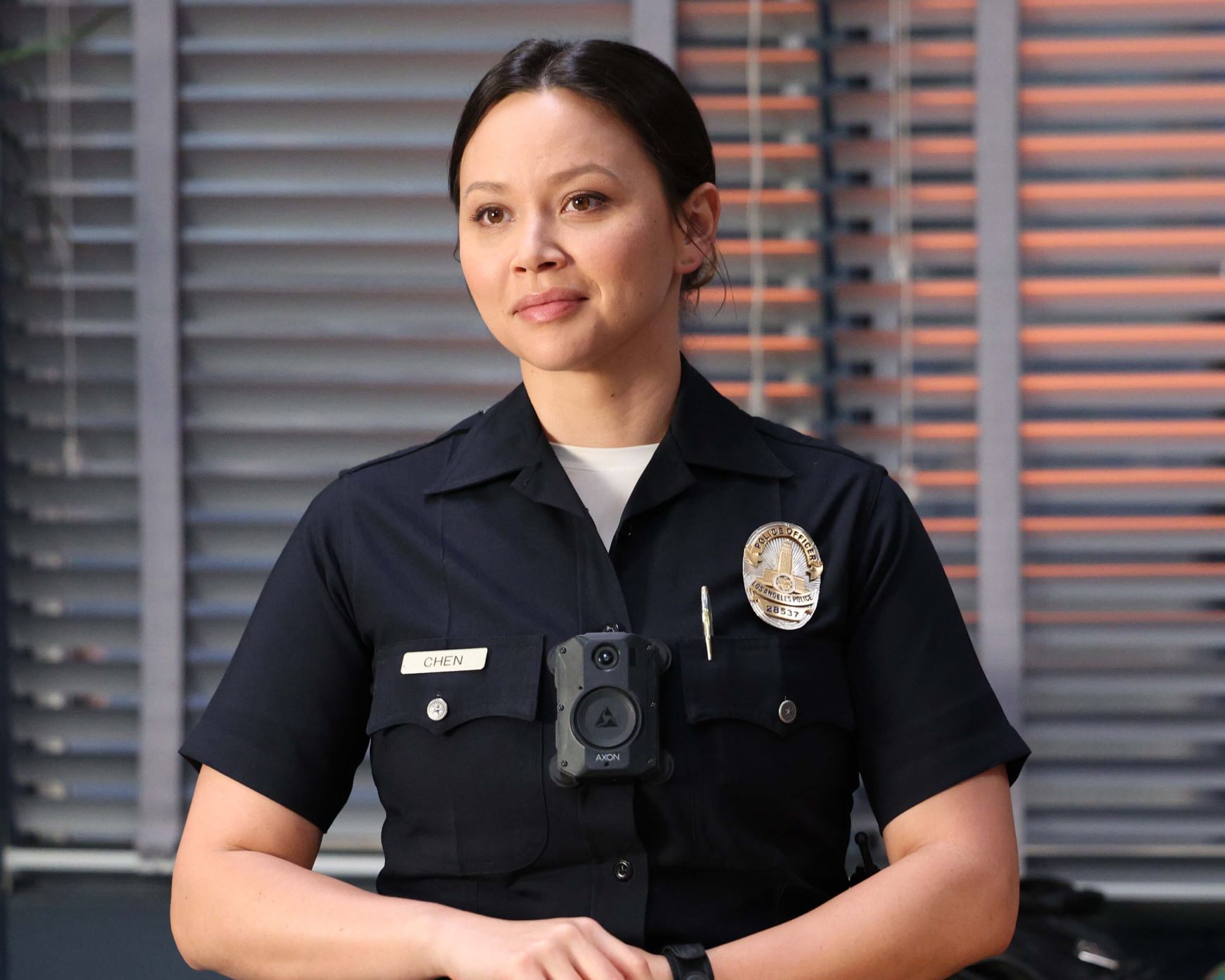 Melissa O'Neil, in character as Lucy Chen in 'The Rookie' Season 5, wears her dark blue police uniform.