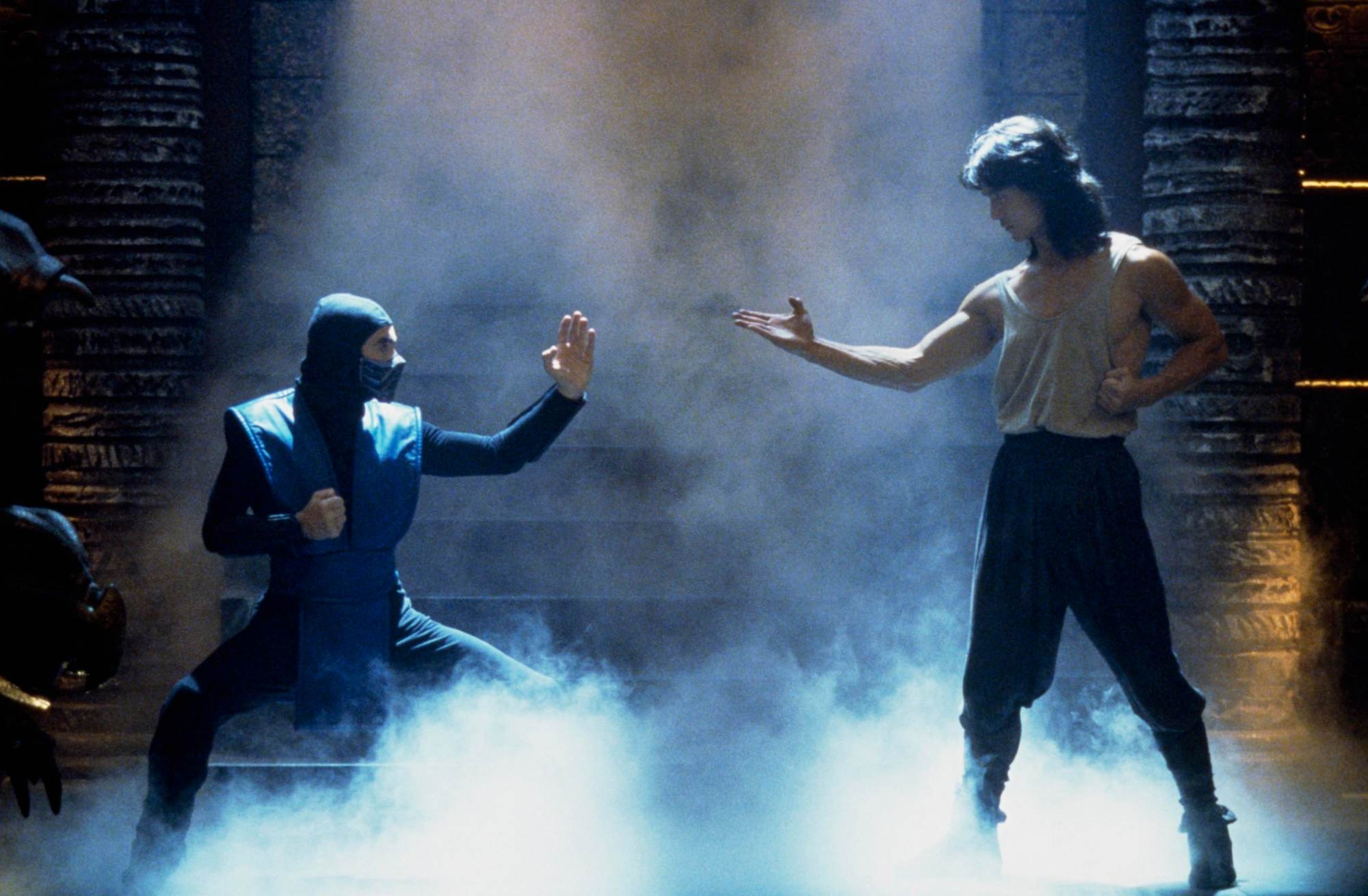 Video game movies 'Mortal Kombat' François Petit as Sub-Zero and Robin Shou as Liu Kang in a fighting pose standing in mist.