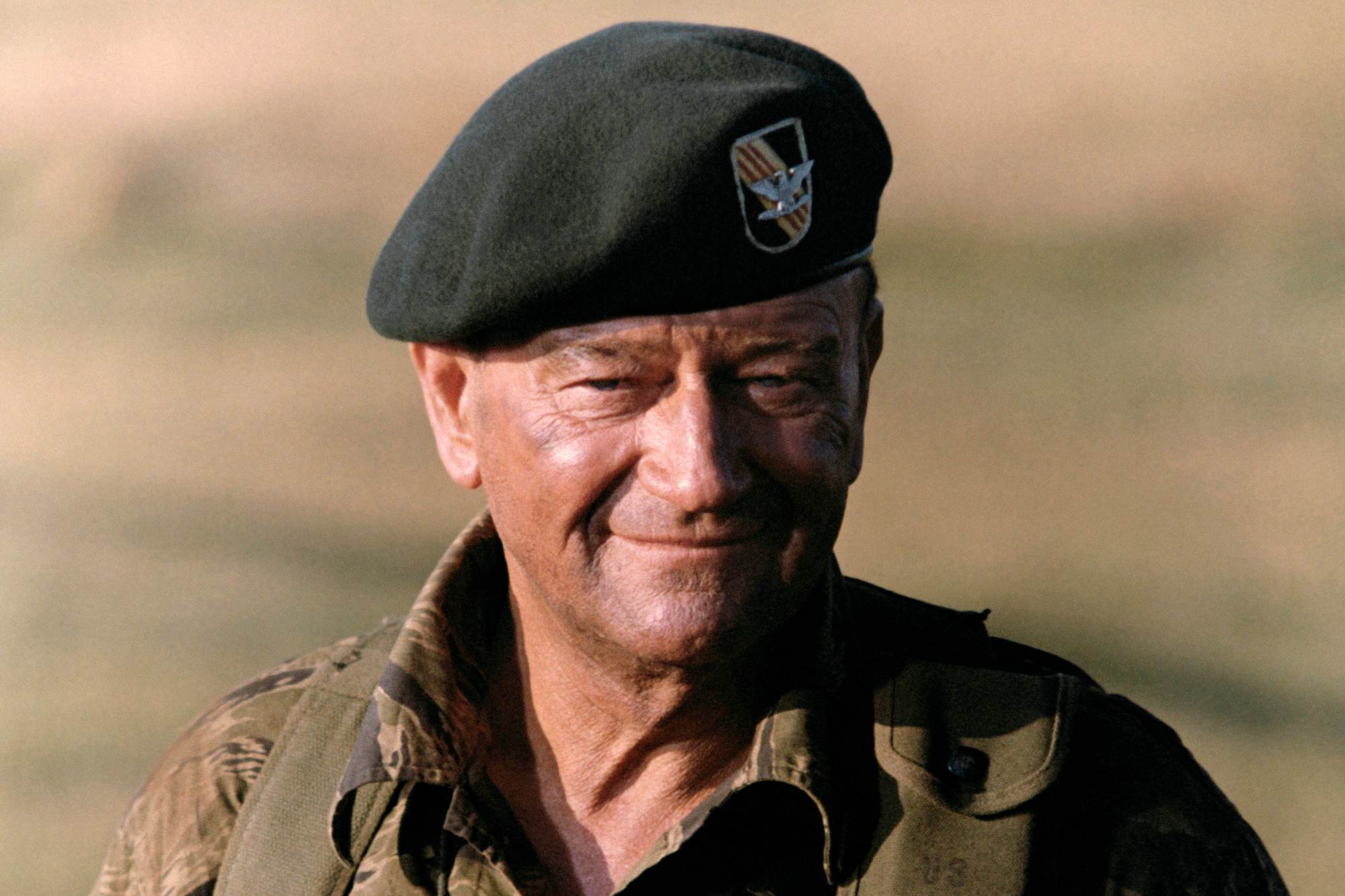Vietnam War supporter John Wayne wearing a Green Berets uniform and smiling.
