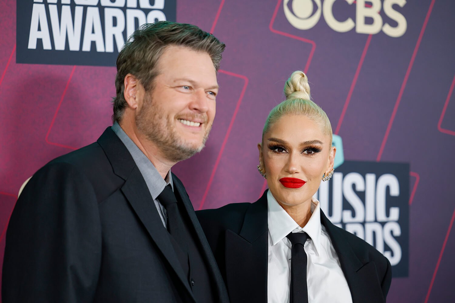 Blake Shelton and Gwen Stefani pose together at the 2023 CMT Music Awards in black suits.