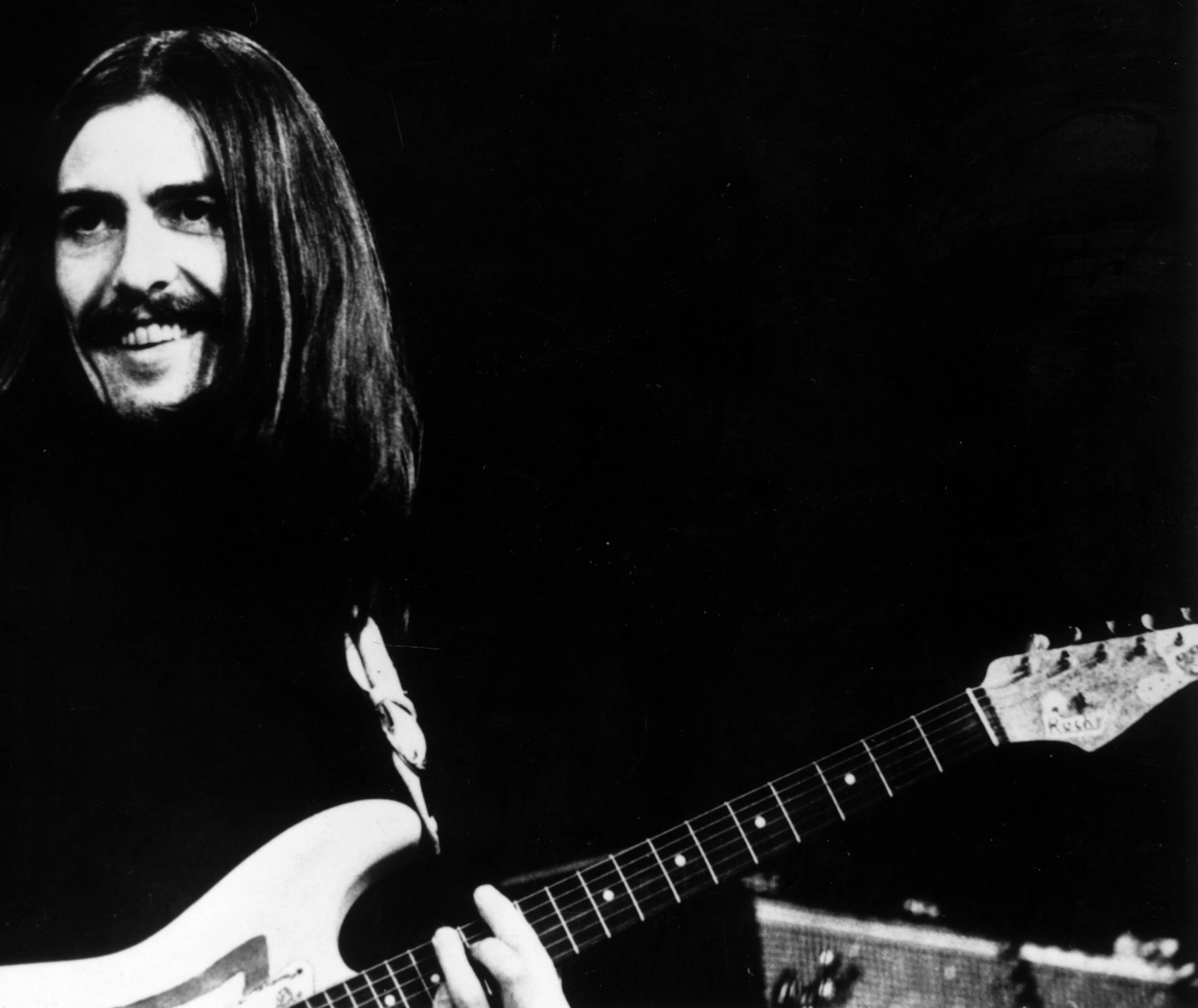 "Any Road" singer George Harrison with a guitar