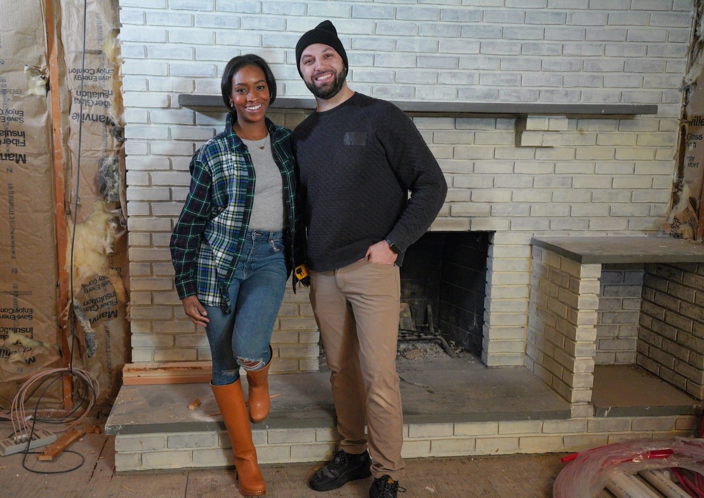 Denese and Mike Butler stand in front of a fireplace on HGTV's Fix My Frankenhouse