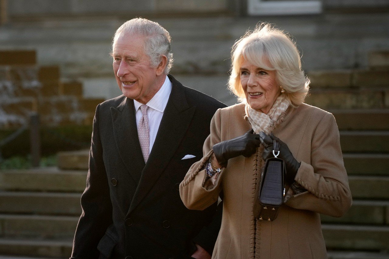 King Charles and Queen Camilla walk together.