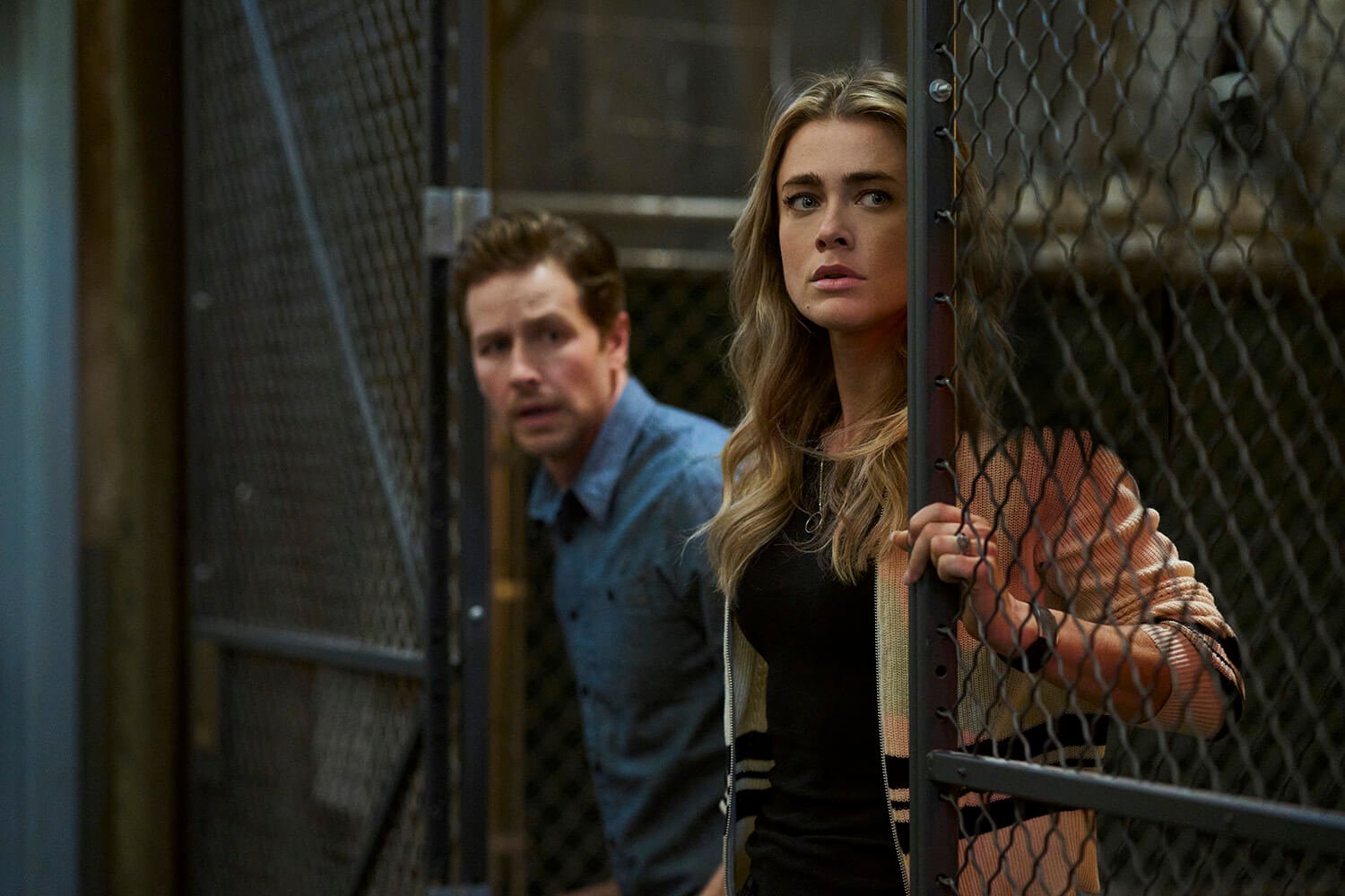 Josh Dallas as Ben Stone and Melissa Roxburgh as Michaela Stone leaning out of a gate in Manifest Season 4 Part 2