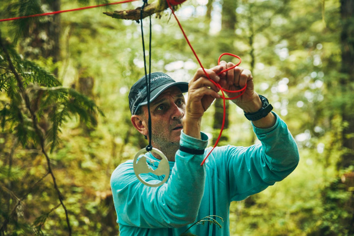 Jeff Leininger ties a red ribbon a tree branch on 'Race to Survive: Alaska'.