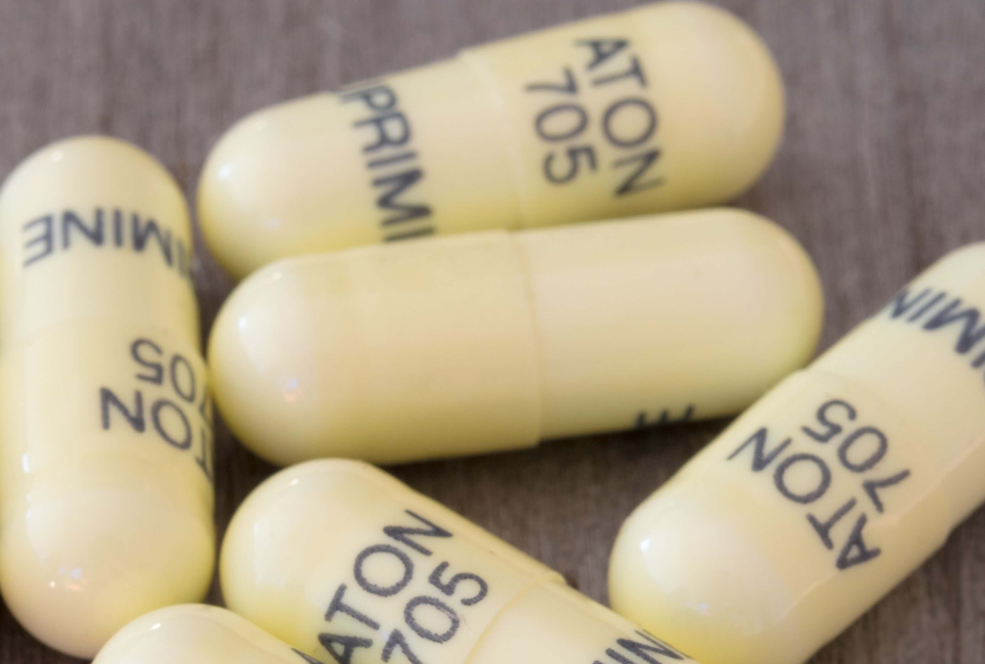 Yellow pills with writing on them