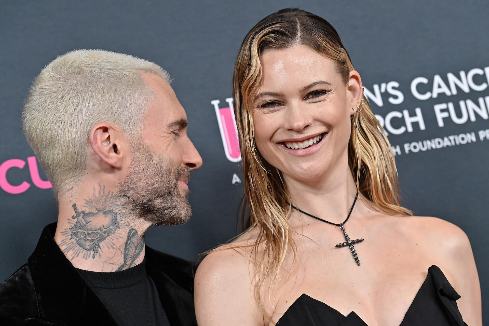 Adam Levine and wife Behati Prinsloo smiling at an event