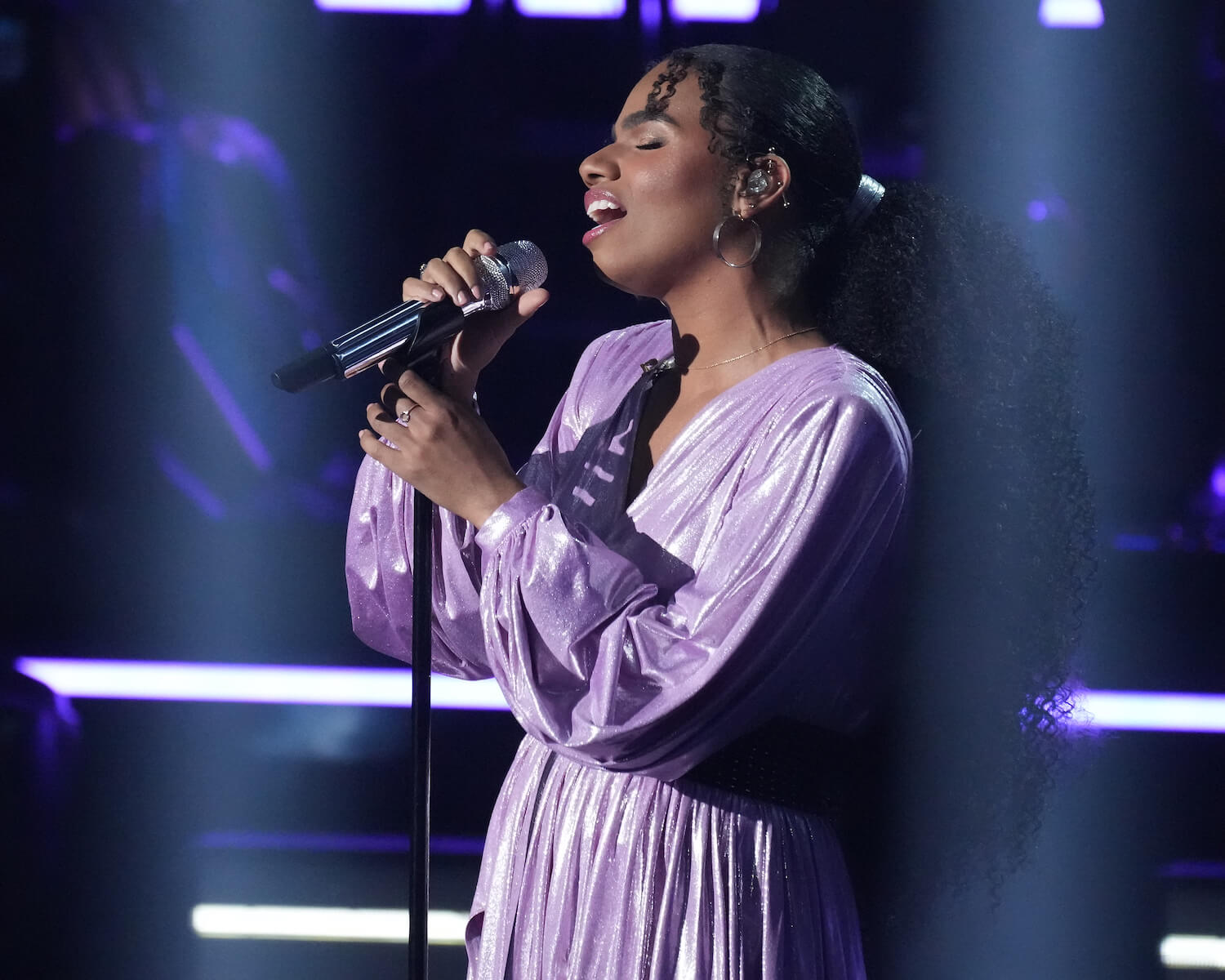 'American Idol' 2023 top 5 contestant Wé Ani singing into a microphone while wearing a purple dress