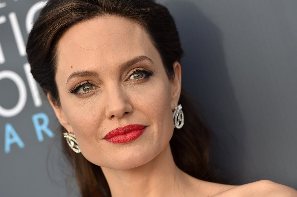 Angelina Jolie smiling while taking a picture at the Critics' Choice Awards.