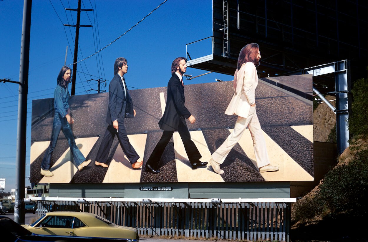 A picture of George Harrison, Paul McCartney, Ringo Starr, and John Lennon on a billboard promoting the Beatles' album 'Abbey Road.'