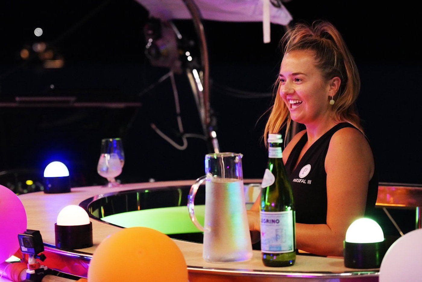 Daisy Kelliher from 'Below Deck Sailing Yacht' stands behind a bar
