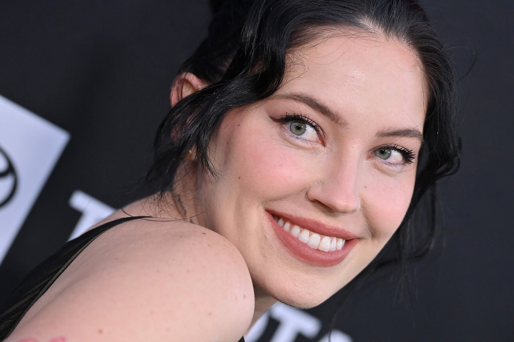 A close-up of Bishop Briggs smiling over her shoulder. Bishop Briggs was Medusa in 'The Masked Singer' Season 9