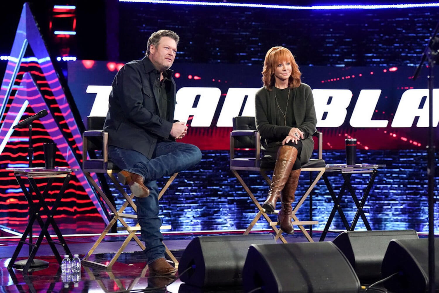 Blake Shelton and Reba McEntire sitting on stage in 'The Voice' Season 23