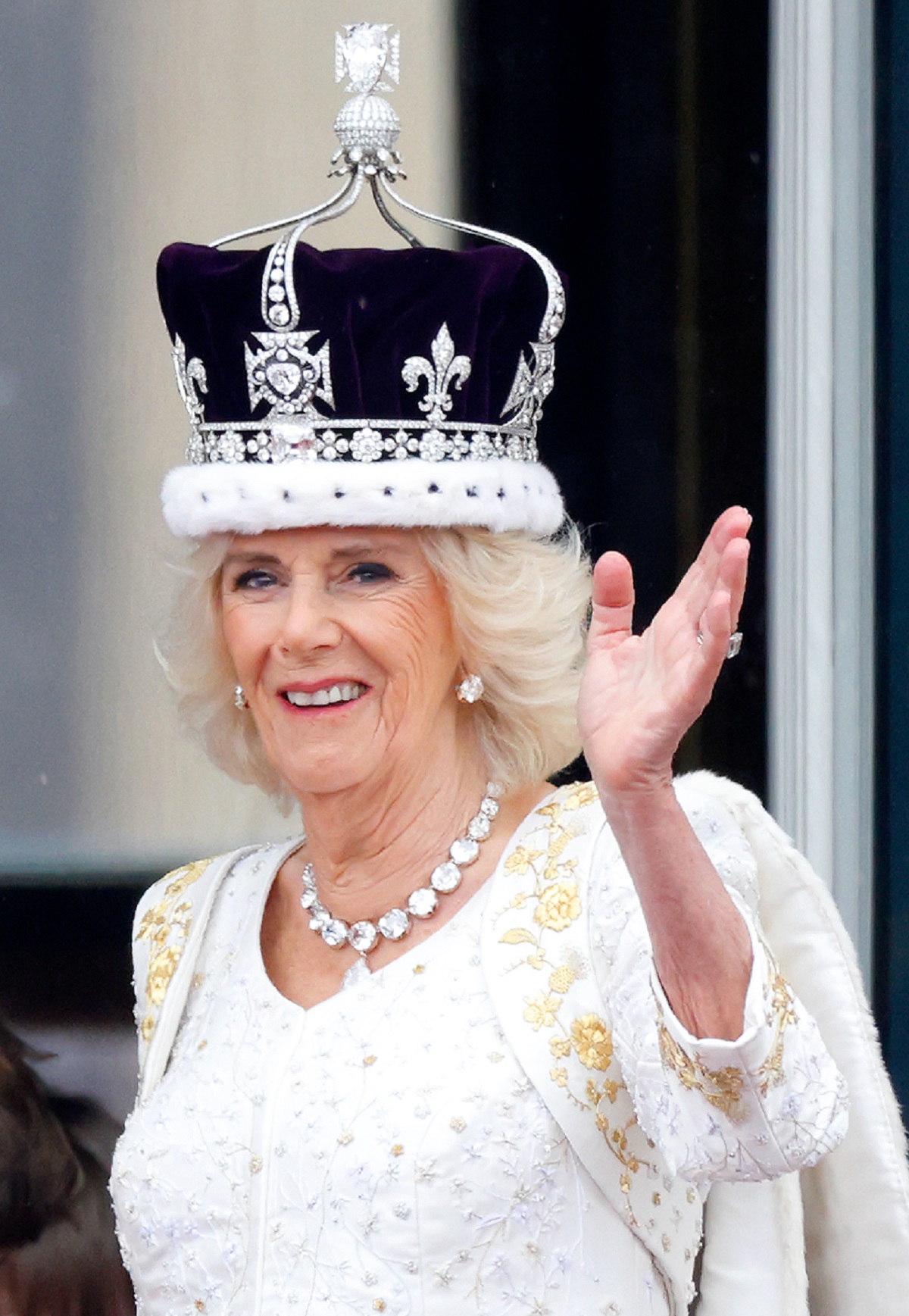 Camilla Parker Bowles waving from the balcony of Buckingham Palace following coronation in a Bruce Oldfield- designed gown