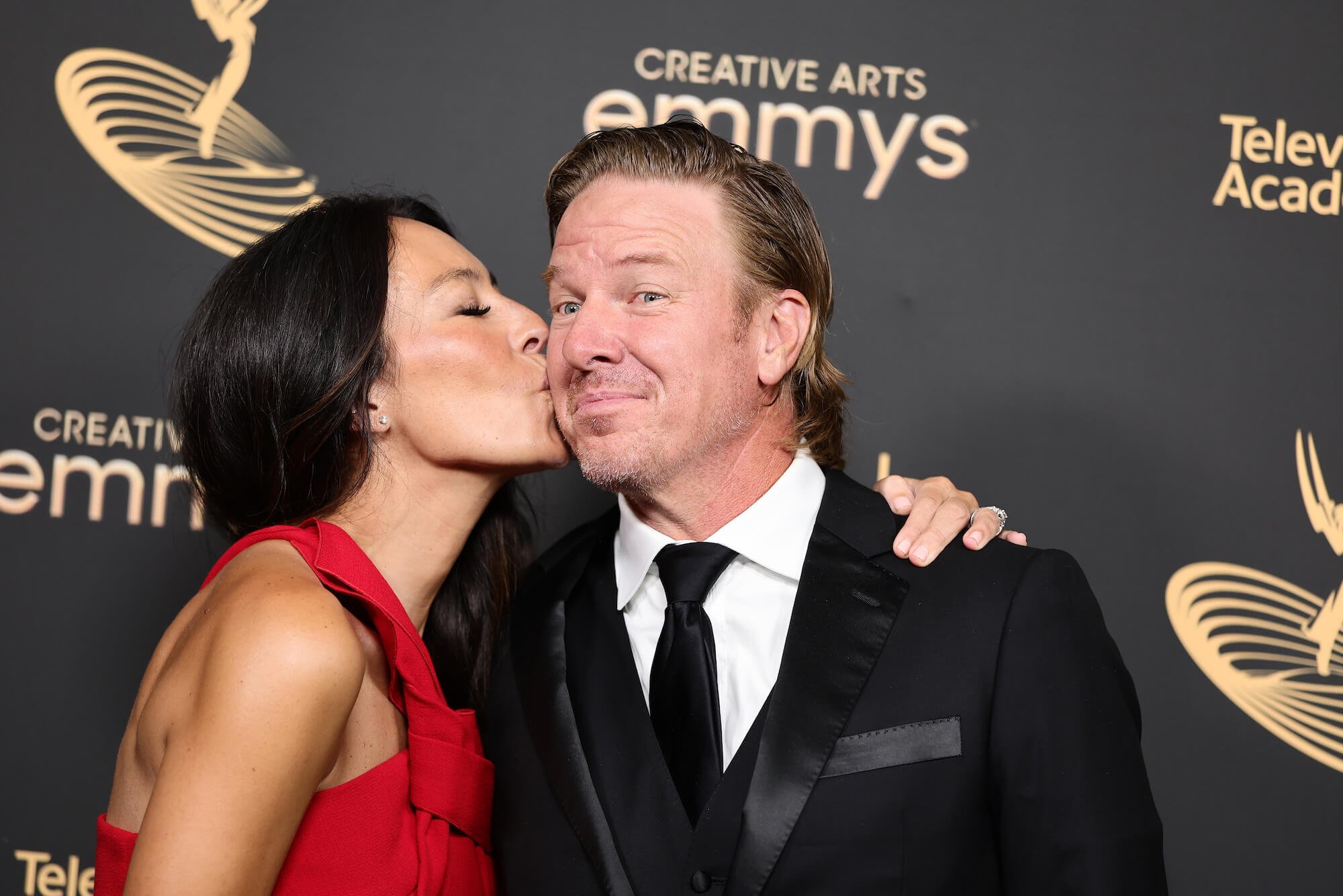 Joanna Gaines from 'Fixer Upper' kissing Chip Gaines on the cheek while standing on the red carpet at the Emmys
