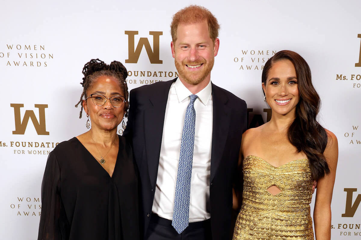 Doria Ragland, Prince Harry, and Meghan Markle smile posing for a photo at the 2023 Women of Vision Awards before a New York car chase