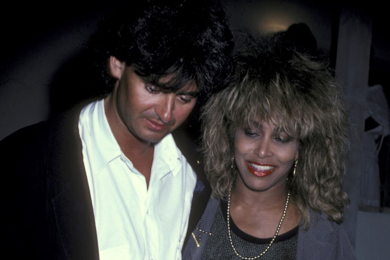 Erwin Bach wears a white shirt and black jacket and Tina Turner wears a silver jacket and necklace.
