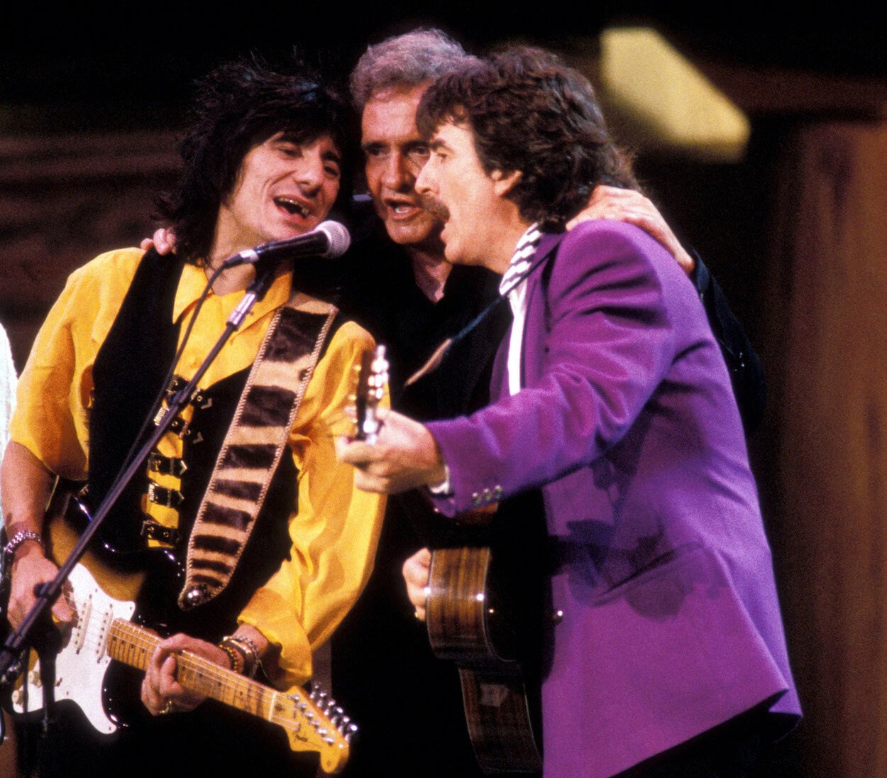 Ronnie Wood (from left) playing guitar while sharing a microphone with Johnny Cash and George Harrison.