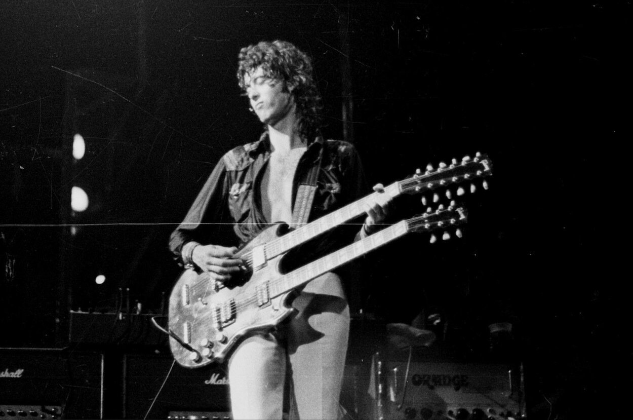 Jimmy Page playing his double-necked guitar with his eyes closed during a 1973 concert.