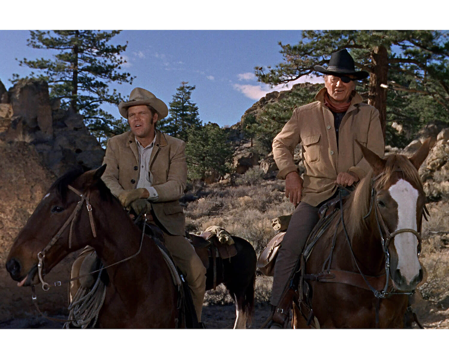 John Wayne and Glen Campbell riding horses in 'True Grit'