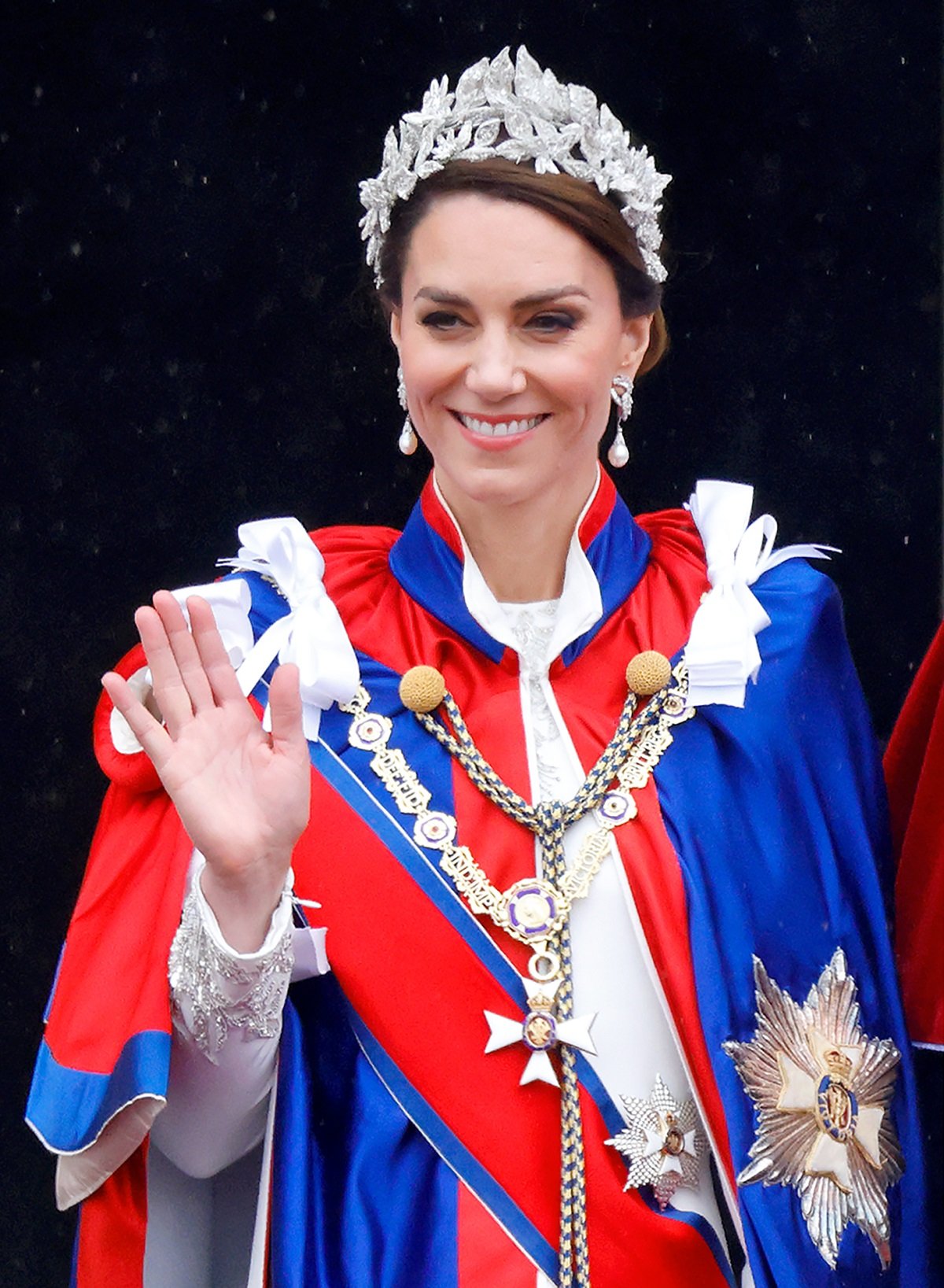 Kate Middleton wearing the Mantle of the Royal Victorian Order robe as she waves the balcony of Buckingham Palace