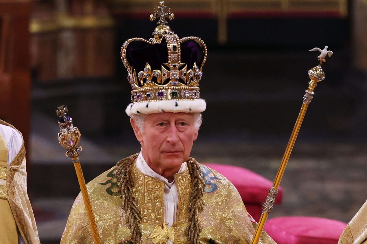 King Charles III, who did not look happy during his coronation, stands after being crowned in Westminster Abbey