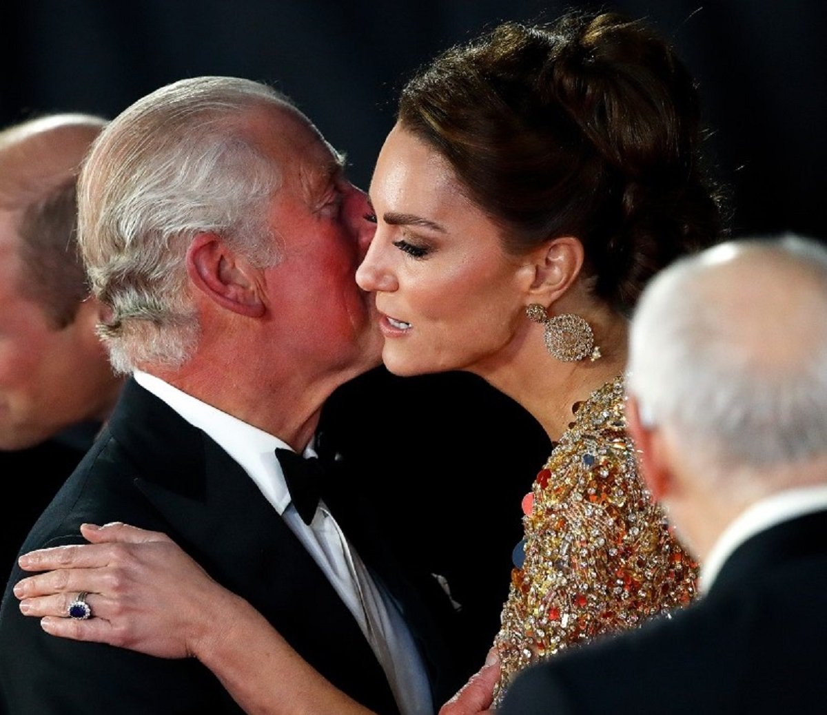 King Charles and Kate Middleton greet each other with a hug and kiss at the No Time To Die premiere