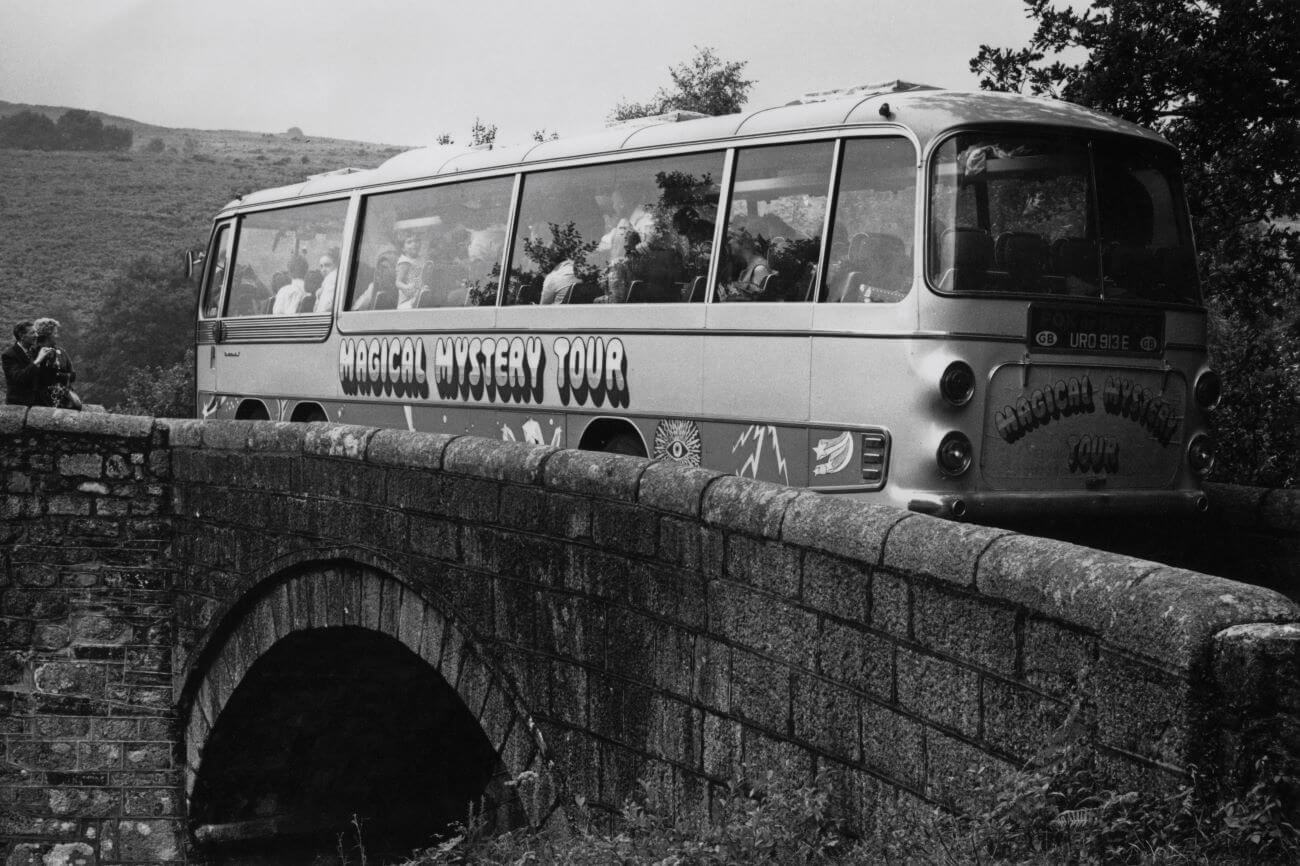 A black and white picture of The Beatles' "Magical Mystery Tour" bus crossing a bridge.